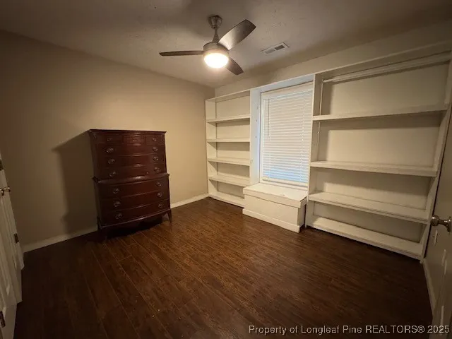 a living room with hard wood floors and a ceiling fan