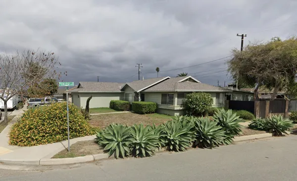 a view of a house with a yard and potted plants
