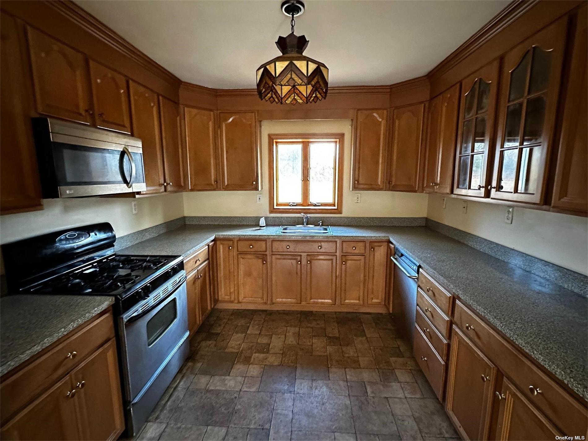 2468 River Road Calverton, NY 11933 - Photo 9 of 20 a kitchen with a stove a sink and a microwave