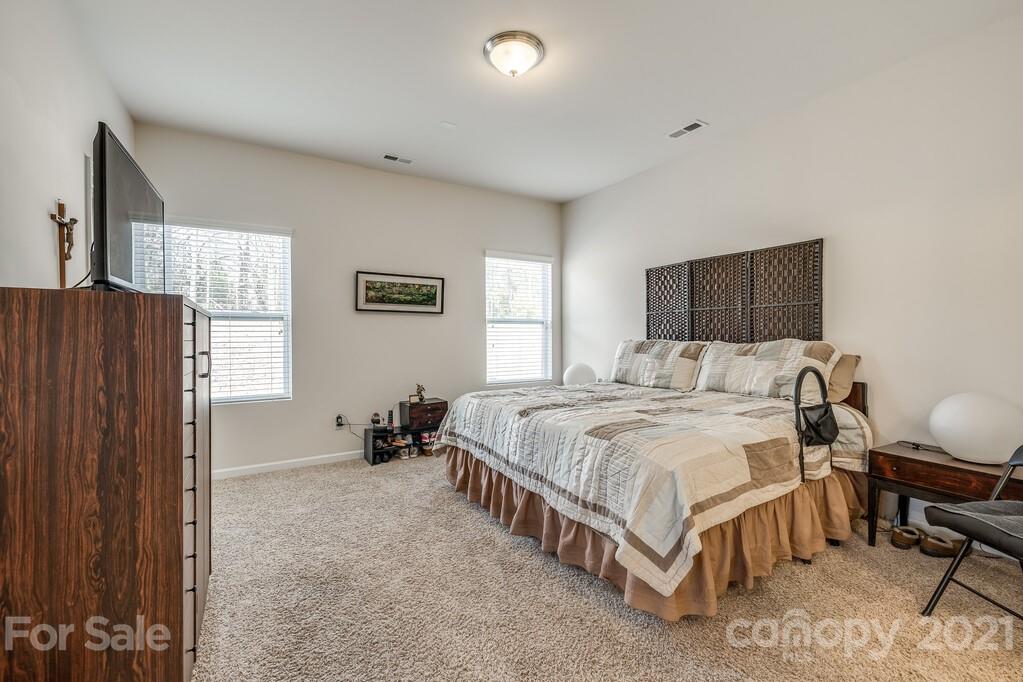 1592 Spring Blossom Trail Fort Mill, SC 29708 - Photo 14 of 36 a spacious bedroom with a bed and wooden floor
