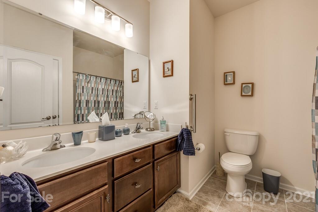 1592 Spring Blossom Trail Fort Mill, SC 29708 - Photo 19 of 36 a bathroom with a toilet sink double vanity and mirror