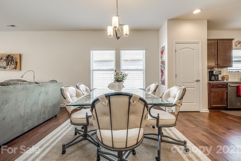 1592 Spring Blossom Trail Fort Mill, SC 29708 - Photo 24 of 36 a dining room with furniture a chandelier and wooden floor
