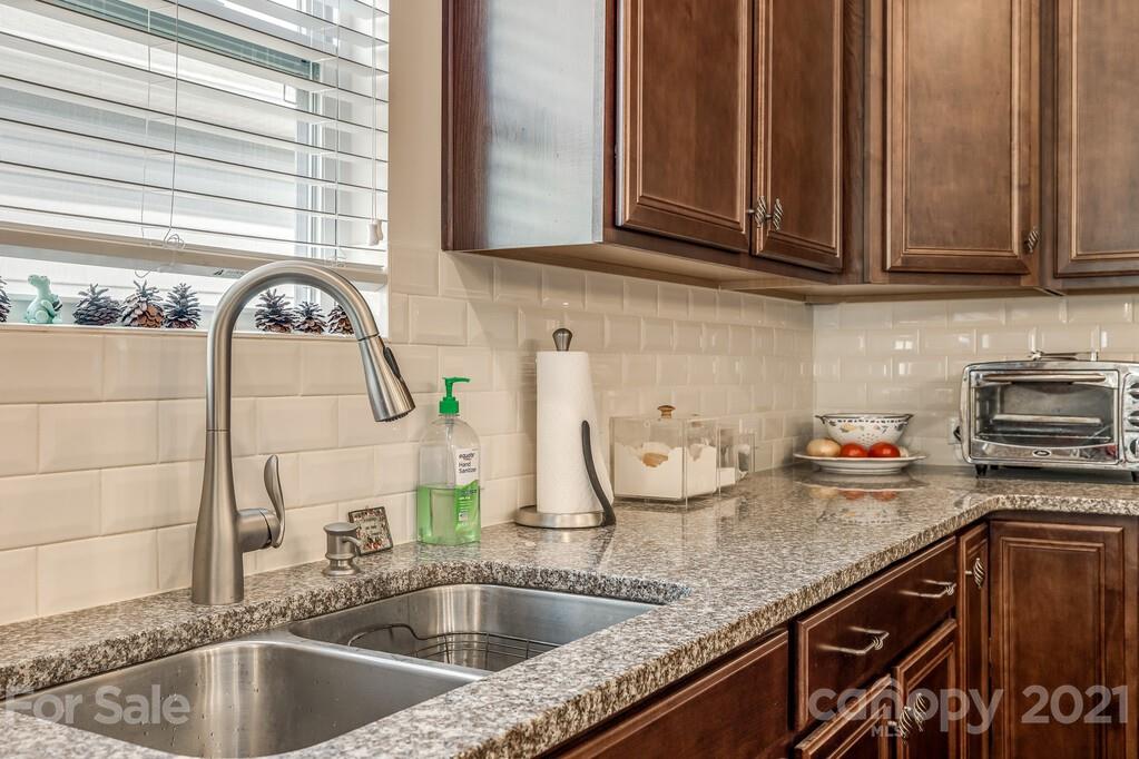 1592 Spring Blossom Trail Fort Mill, SC 29708 - Photo 28 of 36 a kitchen with granite countertop a sink and a wooden floor
