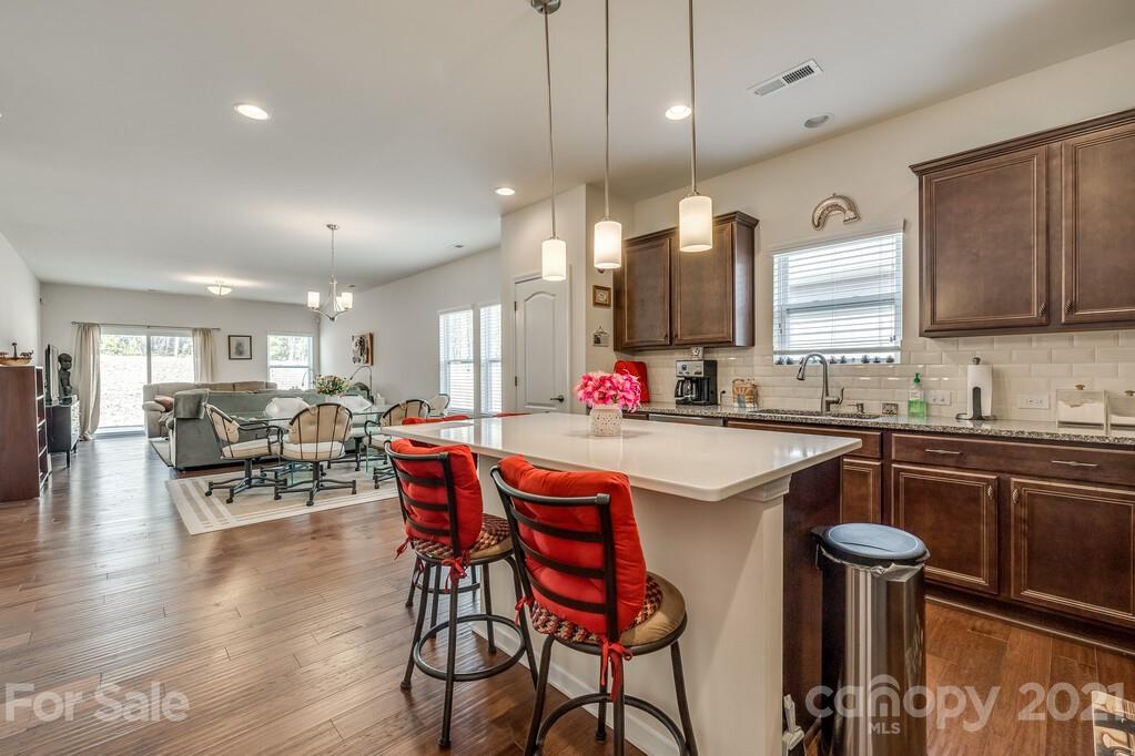 1592 Spring Blossom Trail Fort Mill, SC 29708 - Photo 30 of 36 a kitchen with stainless steel appliances granite countertop a table chairs sink and cabinets