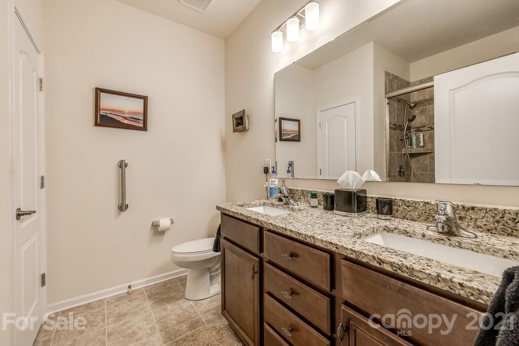 1592 Spring Blossom Trail Fort Mill, SC 29708 - Photo 9 of 36 a bathroom with a granite countertop sink a toilet and a mirror