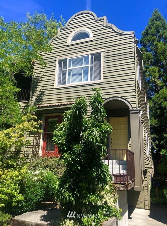 a view of a house with a yard and potted plants