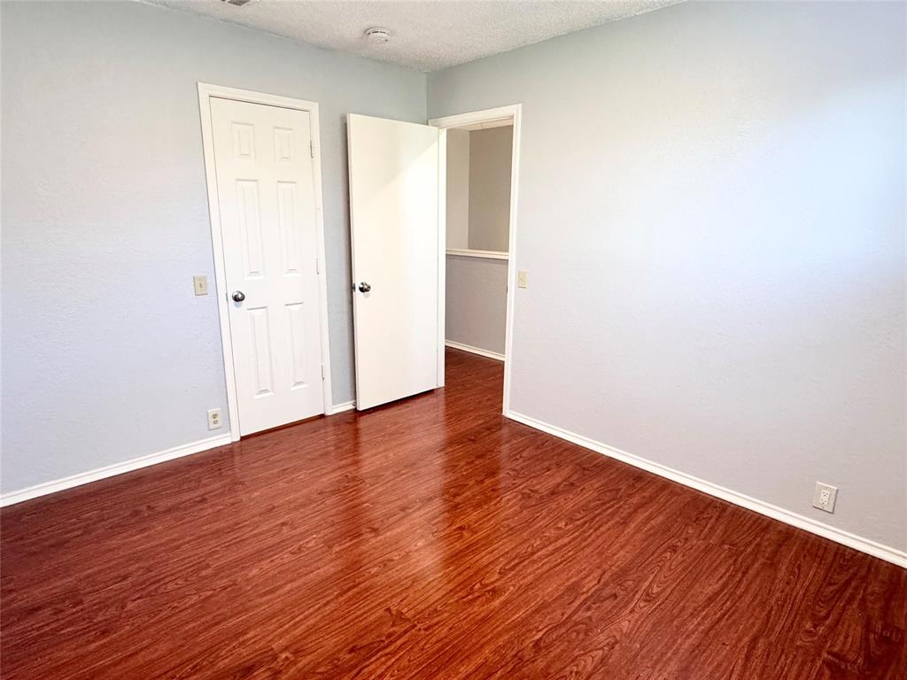 6723 Ambercrest Drive Arlington, TX 76002 - Photo 12 of 31 an empty room with wooden floor and windows