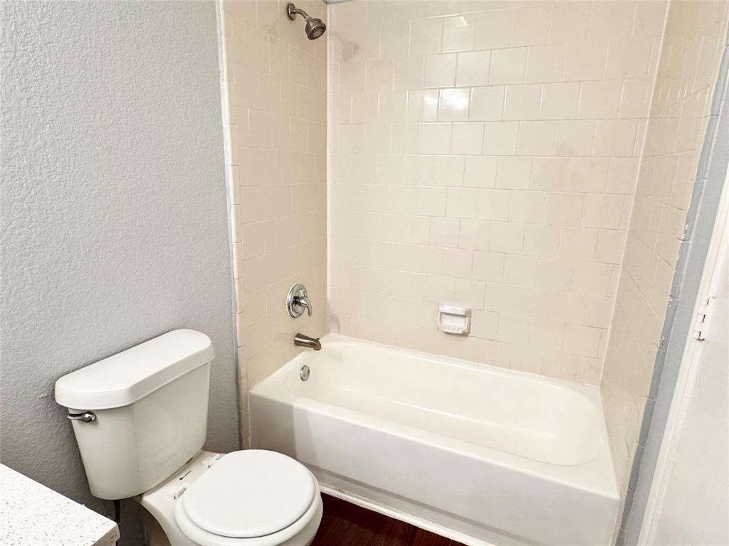 6723 Ambercrest Drive Arlington, TX 76002 - Photo 14 of 31 a white toilet sitting next to a bath tub