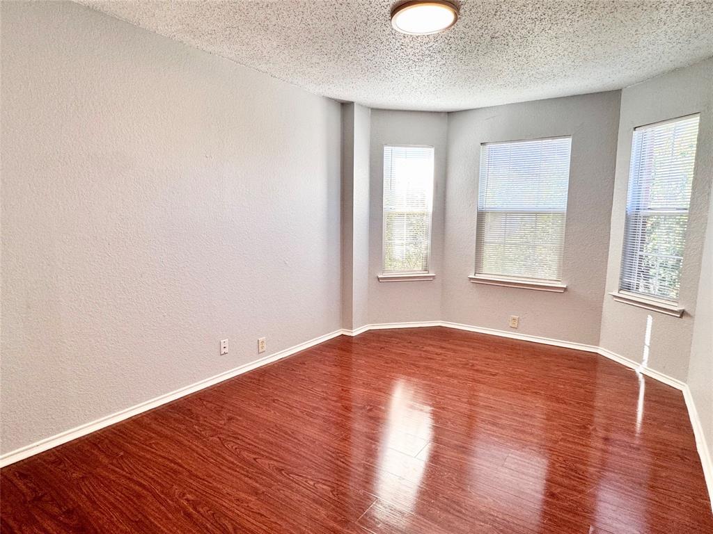 6723 Ambercrest Drive Arlington, TX 76002 - Photo 15 of 31 an empty room with wooden floor and windows