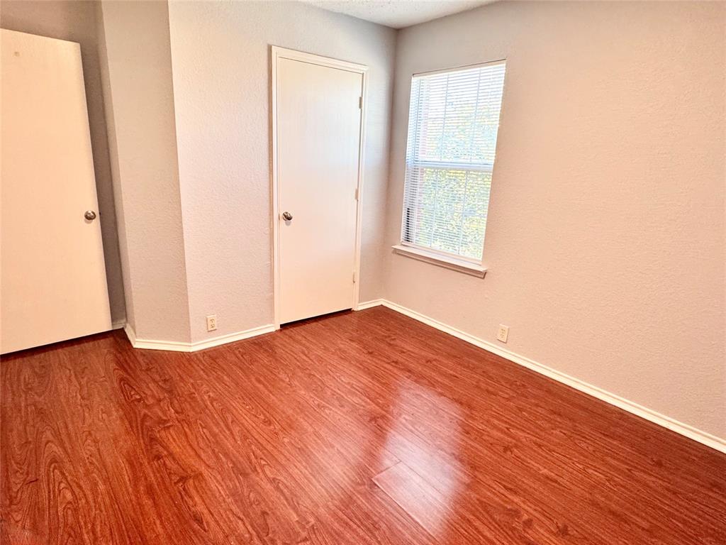 6723 Ambercrest Drive Arlington, TX 76002 - Photo 19 of 31 an empty room with wooden floor and windows