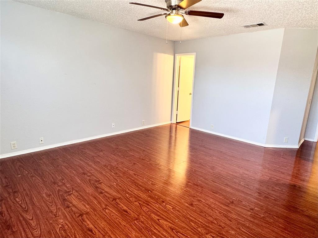 6723 Ambercrest Drive Arlington, TX 76002 - Photo 22 of 31 an empty room with wooden floor fan and windows