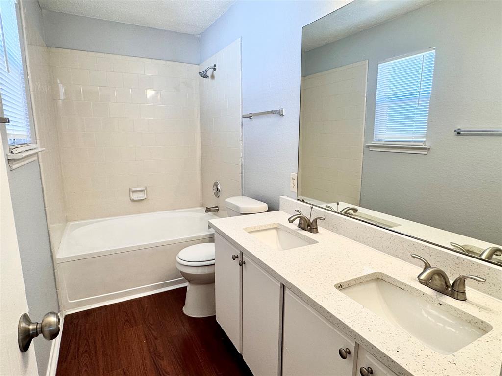 6723 Ambercrest Drive Arlington, TX 76002 - Photo 25 of 31 a bathroom with a double vanity sink toilet mirror and bathtub