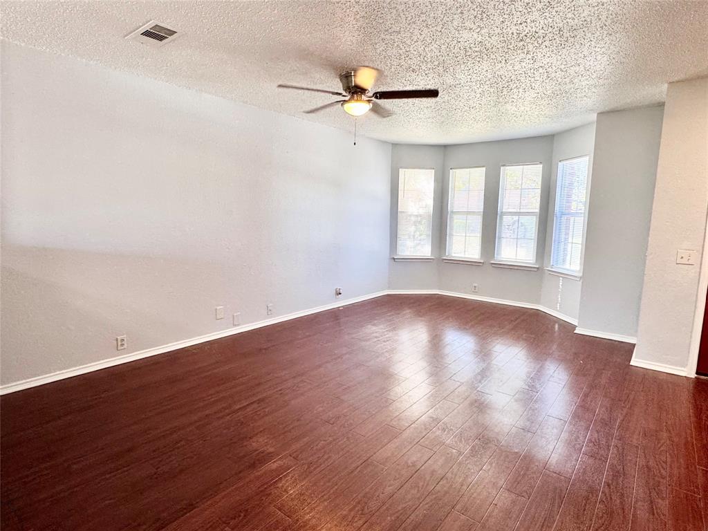 6723 Ambercrest Drive Arlington, TX 76002 - Photo 3 of 31 a view of an empty room with wooden floor and a window