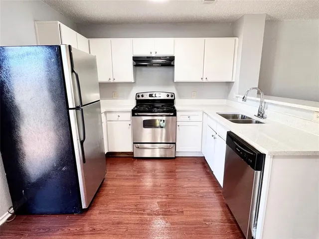 a kitchen with a sink a refrigerator and a stove top oven