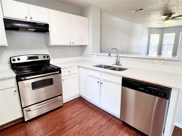 a kitchen with white cabinets and appliances