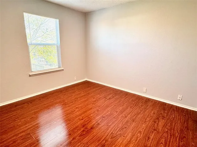 an empty room with wooden floor and a window