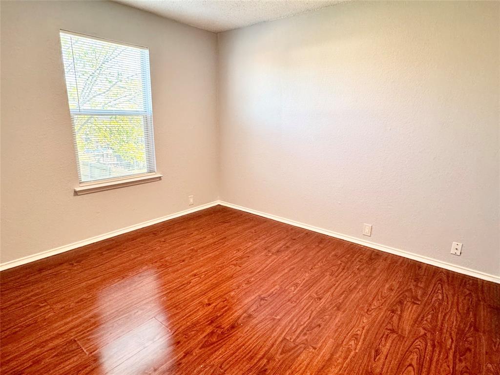 6723 Ambercrest Drive Arlington, TX 76002 - Photo 10 of 31 an empty room with wooden floor and a window