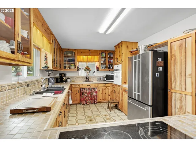 a kitchen with stainless steel appliances kitchen island granite countertop a refrigerator and a stove top oven