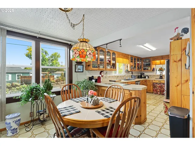 a view of a dining room and livingroom with furniture wooden floor a chandelier