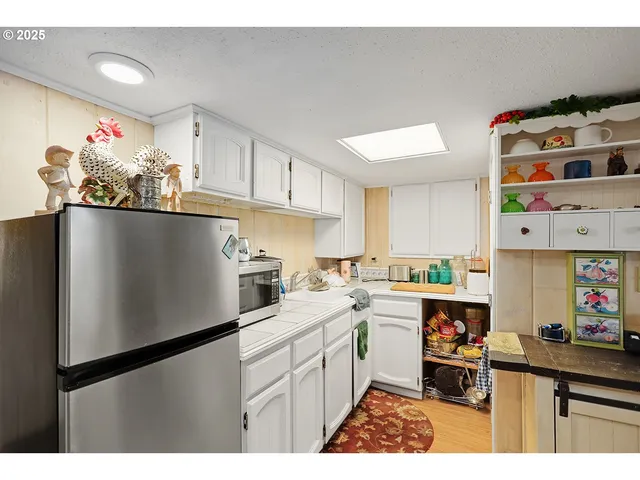 a kitchen with a sink a refrigerator and cabinets