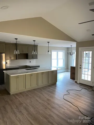 a large kitchen with a wooden floor and a large window