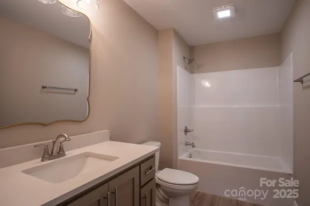 a bathroom with a sink toilet vanity and shower