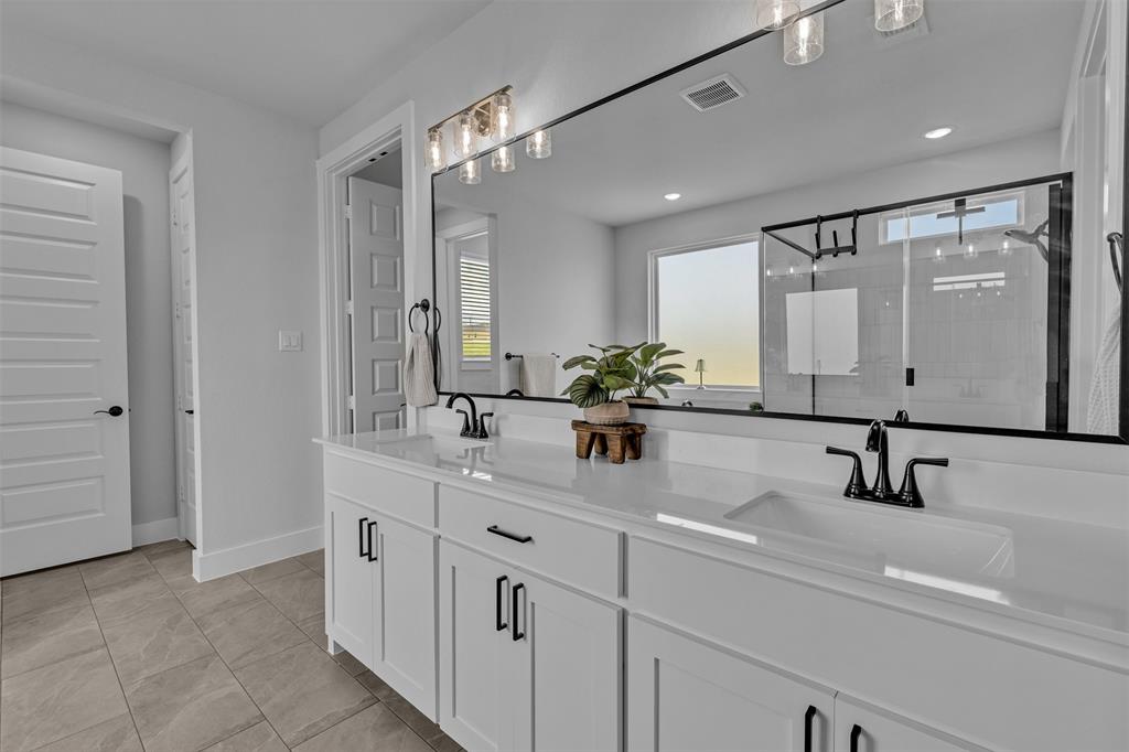 2004 Willy Dilly Road Springtown, TX 76082 - Photo 28 of 40 Double vanity with white cabinetry, matte black hardware, and integrated sinks