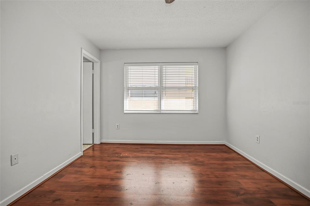 11655 3rd Street East, Unit 19 Treasure Island, FL 33706 - Photo 13 of 48 an empty room with wooden floor and windows