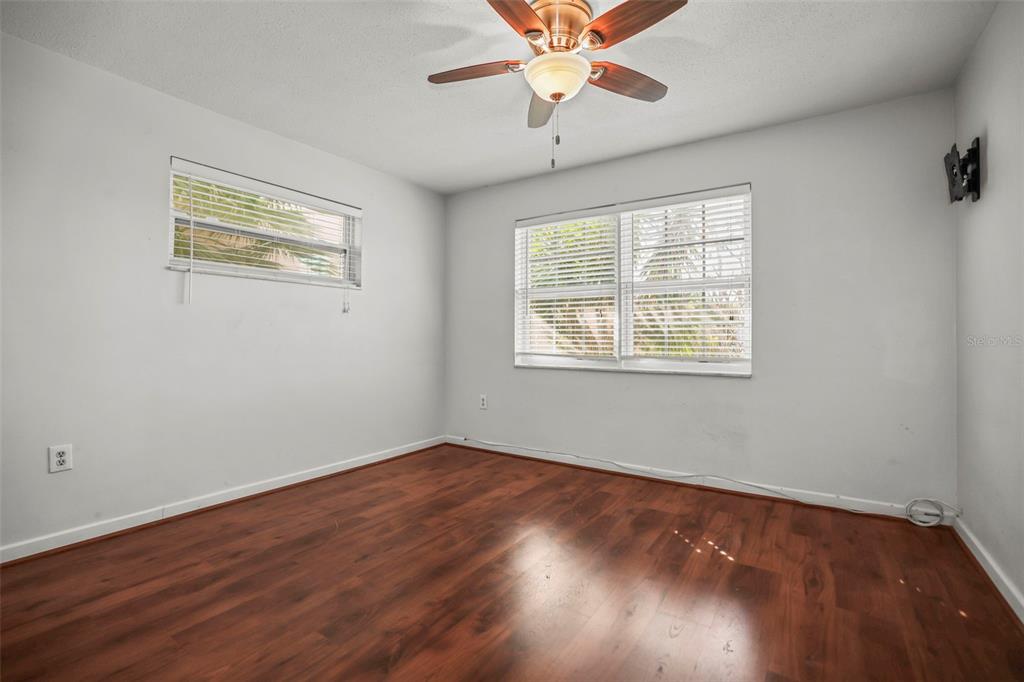11655 3rd Street East, Unit 19 Treasure Island, FL 33706 - Photo 17 of 48 a view of an empty room with wooden floor and a window