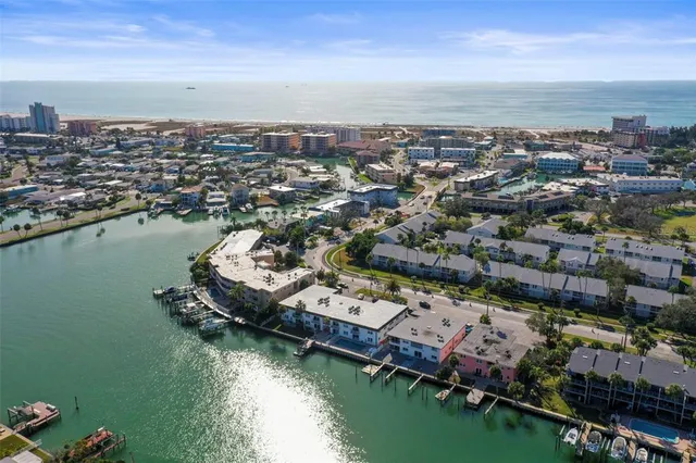 an aerial view of a city with lots of residential buildings ocean and mountain view in back