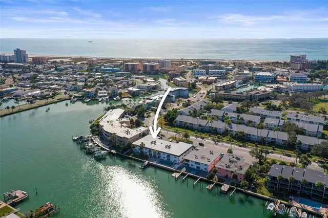 an aerial view of a city with lots of residential buildings ocean and mountain view in back
