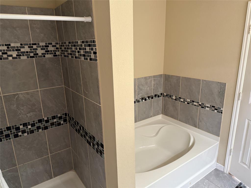5718 Green Ivy Road Denton, TX 76210 - Photo 12 of 23 Bathroom featuring a garden tub, a shower stall, and tile patterned floors