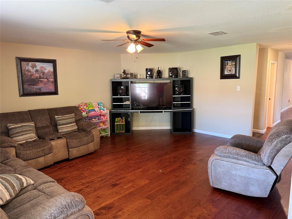 5718 Green Ivy Road Denton, TX 76210 - Photo 7 of 23 Living area with wood finished floors and a ceiling fan