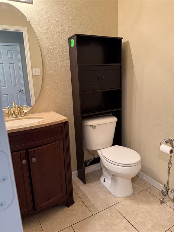 5718 Green Ivy Road Denton, TX 76210 - Photo 8 of 23 Half bath featuring a textured wall, vanity, and light tile patterned floors