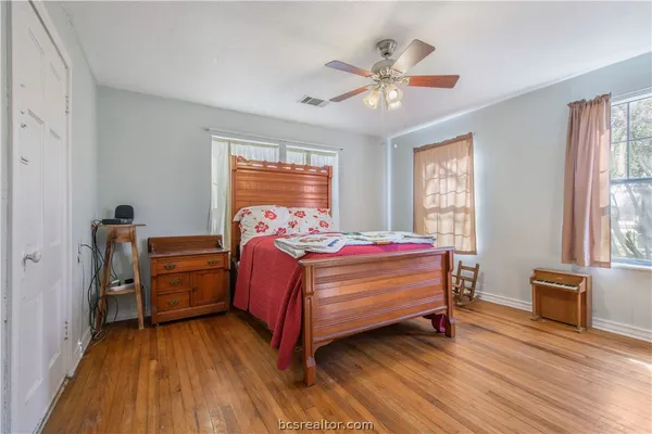 a bedroom with a bed and wooden floor
