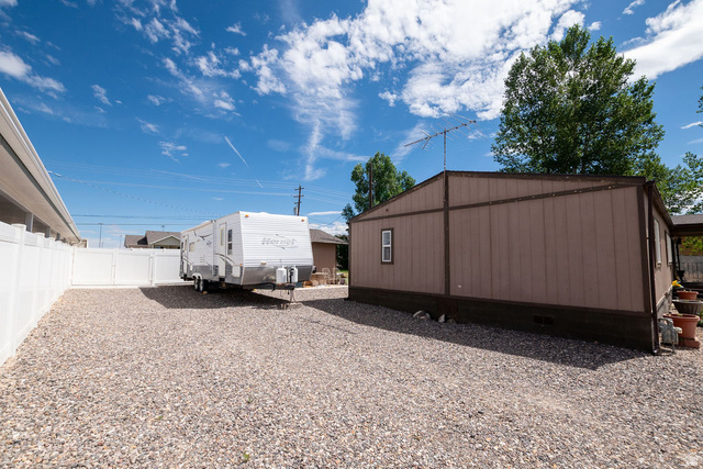 855 East 300 N Street Beaver, UT 84713 - Photo 16 of 44 Expansive gravel area providing ample off-street parking, enclosed by a white privacy fence, offering space for recreational vehicles