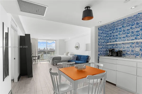 a kitchen with stainless steel appliances granite countertop a sink dishwasher and a refrigerator with wooden floor