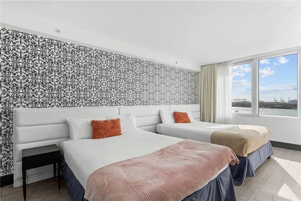 a bedroom with beds and a large window