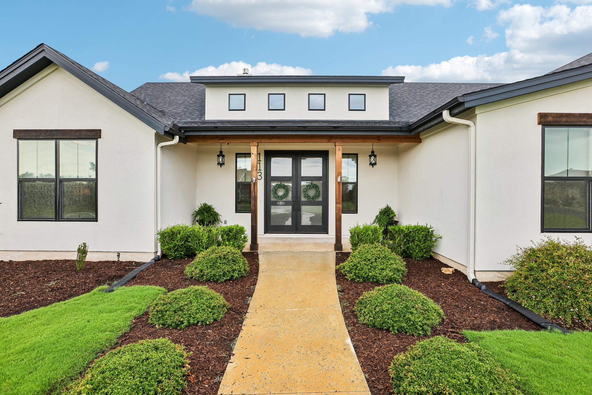 113 Crystal Lane Georgetown, TX 78633 - Photo 12 of 32 A graceful entry with double glass doors welcomes you, flanked by charming exterior lanterns and manicured landscaping.