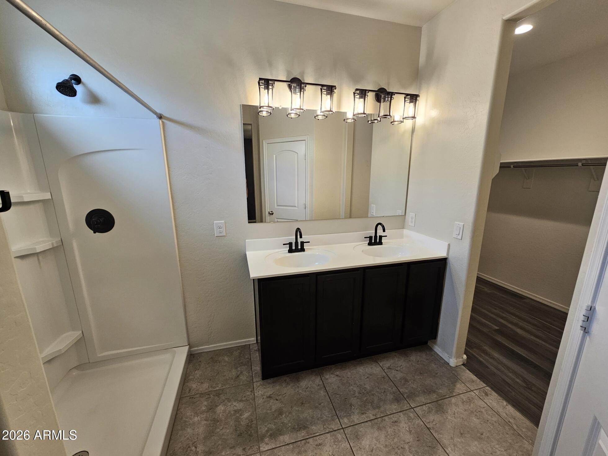 25573 West Coles Road Buckeye, AZ 85326 - Photo 6 of 12 a bathroom with a sink a mirror and shower