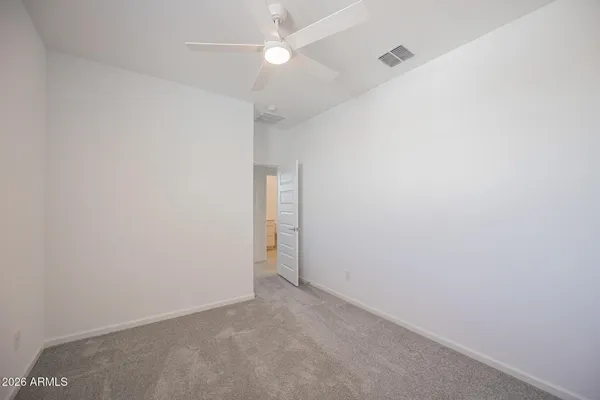 an empty room with a ceiling fan and a fan