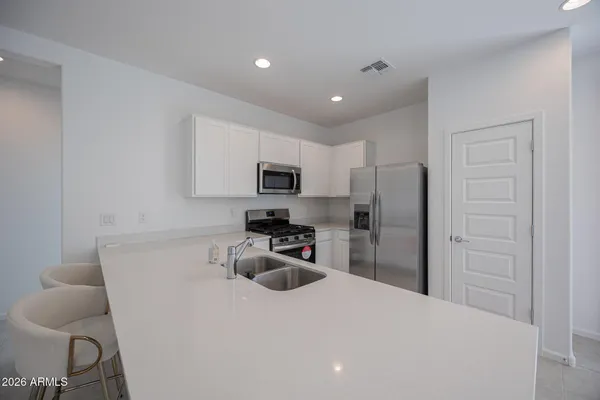 a kitchen with stainless steel appliances a refrigerator stove microwave and sink