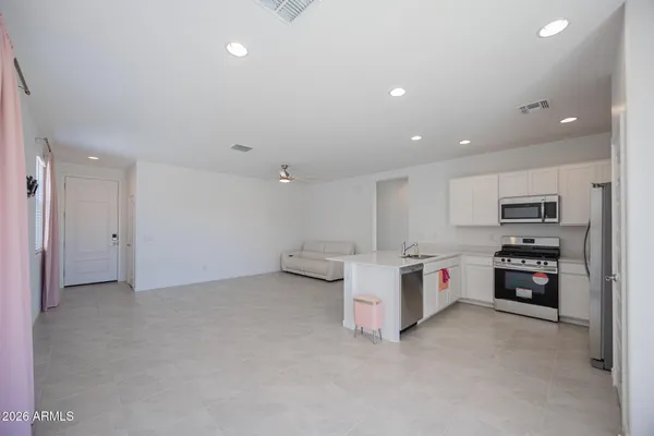 a view of kitchen with stainless steel appliances refrigerator and stove top oven