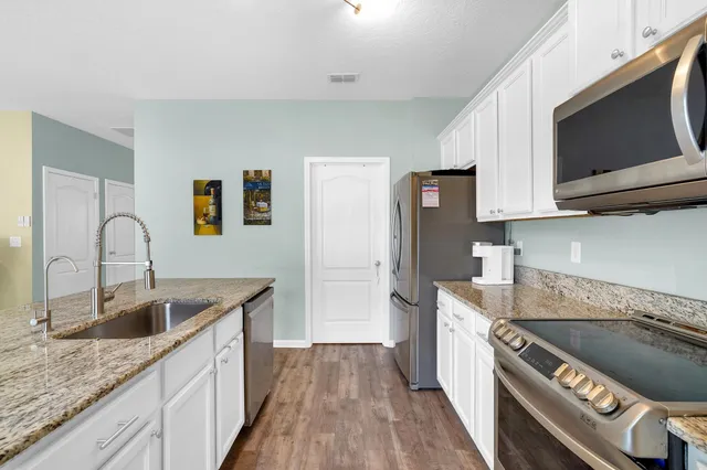 a kitchen with granite countertop a sink and a stove top oven