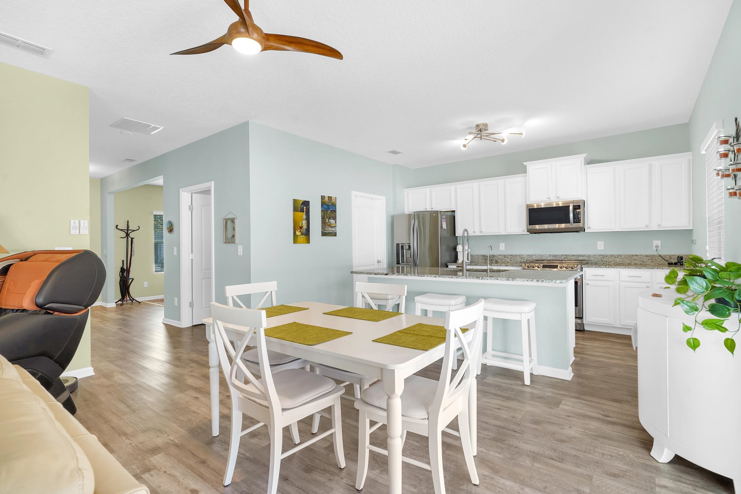 167 Codman Drive St. Augustine, FL 32084 - Photo 9 of 40 a kitchen with stainless steel appliances granite countertop a stove top oven a dining table and chairs with wooden floor