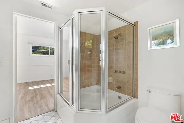 a bathroom with a glass shower door and a toilet