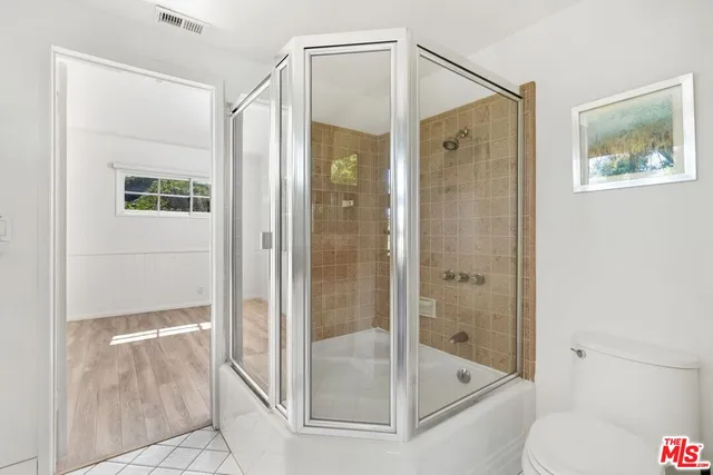 a bathroom with a glass shower door and a toilet