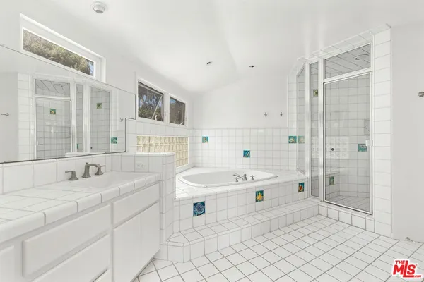 a spacious bathroom with a sink mirror and a bathtub