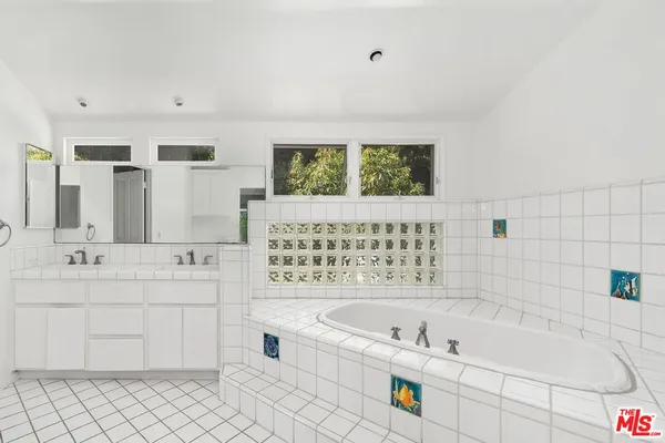 a bathroom with a bathtub sink and mirror