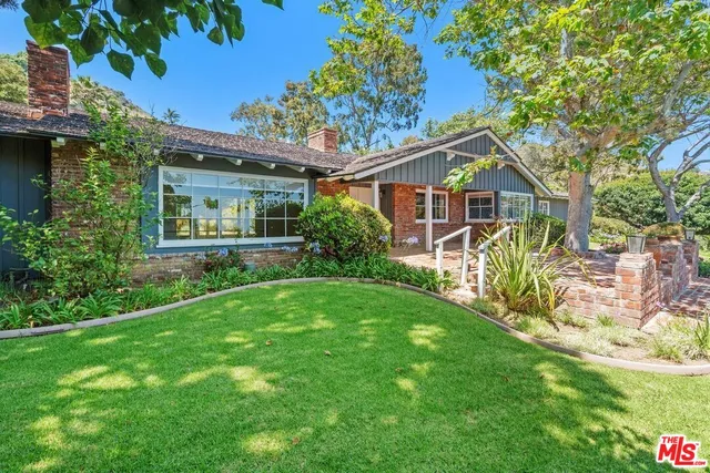 a view of a house with garden and a tree